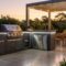 Modern outdoor kitchen with grill, sink, stone countertops and seating area in backyard.
