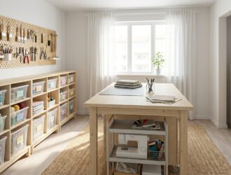 Organized craft room with shelving, bins, and work table in a bright hobby studio layout.
