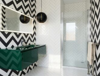 Bold wallpaper and sleek fixtures achieving max impact in tiny powder room.