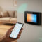 Smart thermostat on wall displaying Wi‑Fi app controls, showing modern home climate management.